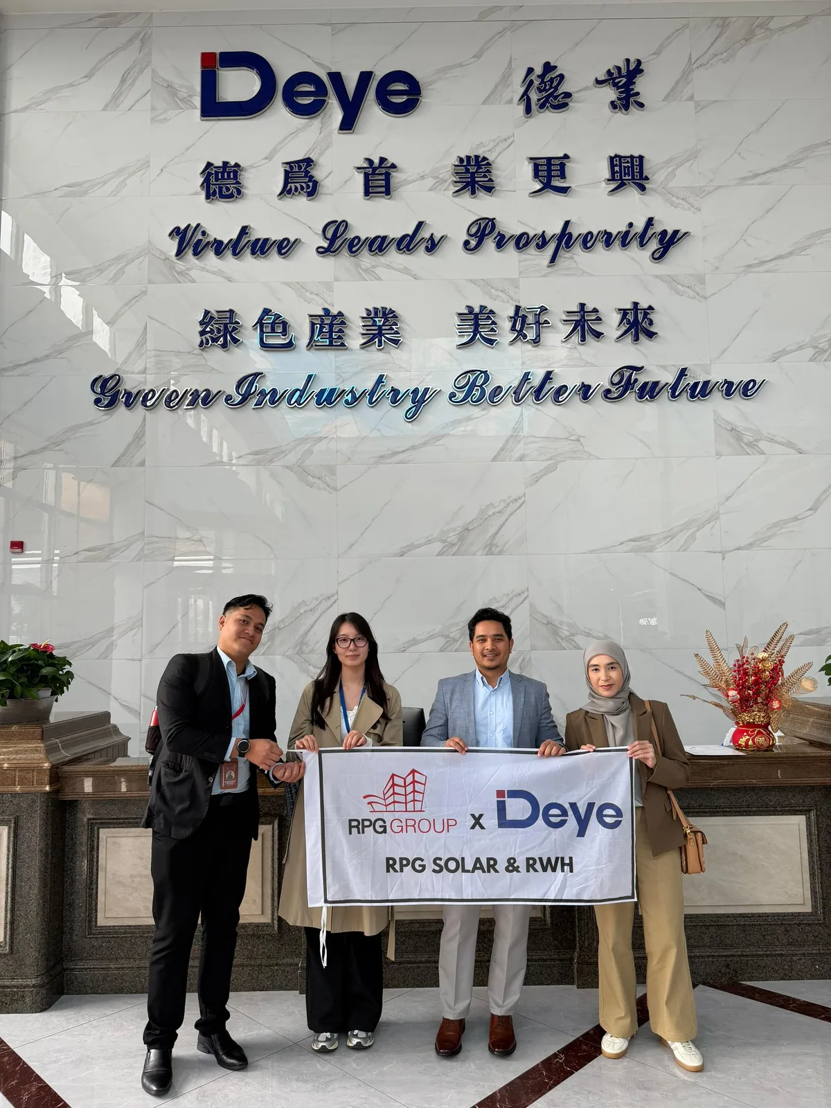 RPG Solar & RWH team holding an RPG Solar x Deye banner in front of the Deye headquarters lobby in Guangdong, China