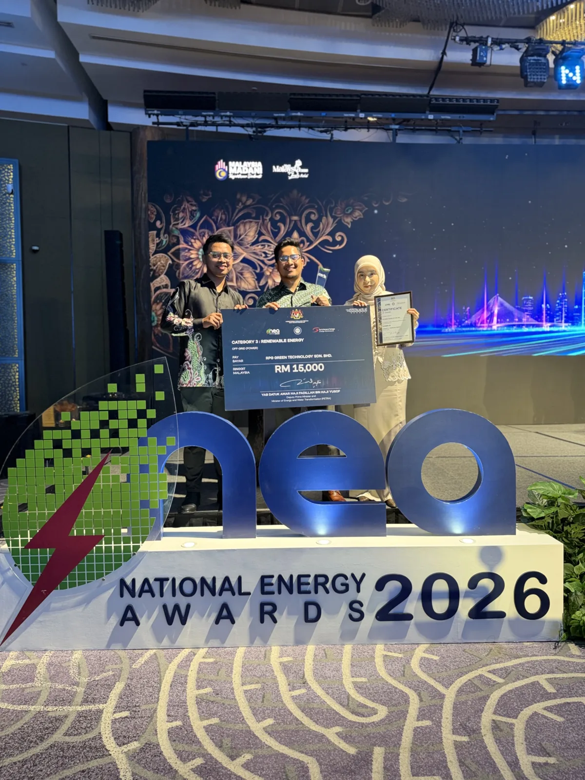 RPG Green Technology team on stage receiving the Renewable Energy Runner-Up award and a RM15,000 cheque at the National Energy Awards 2026, in front of the NEA 2026 stage sign