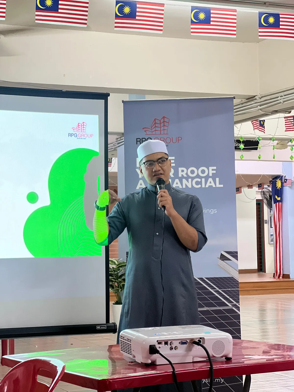 RPG Solar representative giving a community talk on rooftop solar financing, with a presentation slide in the background