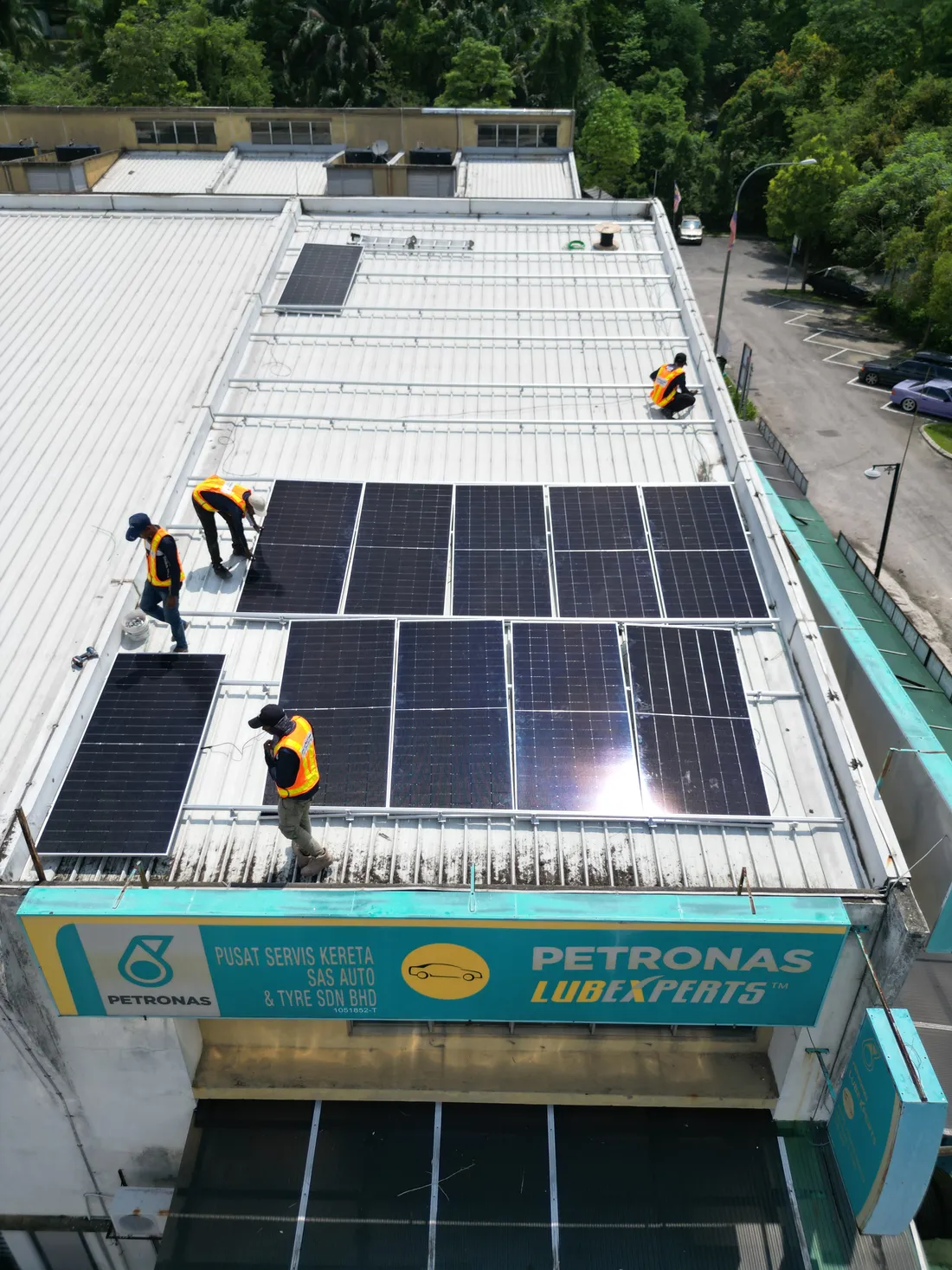 Aerial view of solar panels being installed on the rooftop of a Petronas Lubexperts car service centre
