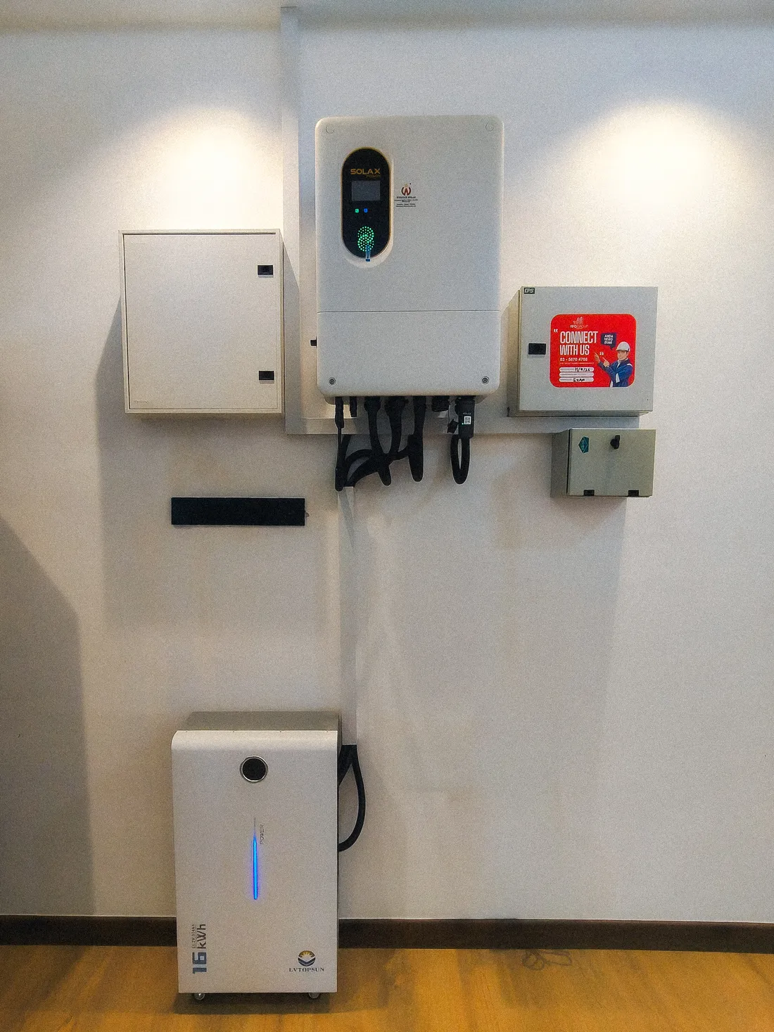 Close-up of a completed hybrid inverter and battery installation mounted on an interior wall